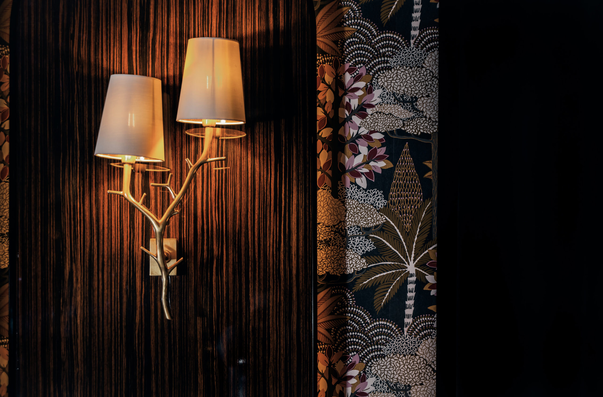 Brass branch sconce against ebony panelling